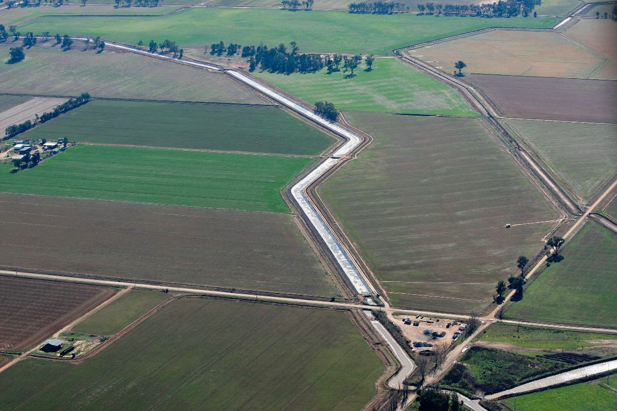 Ariel view of a water channel running through farm paddocks